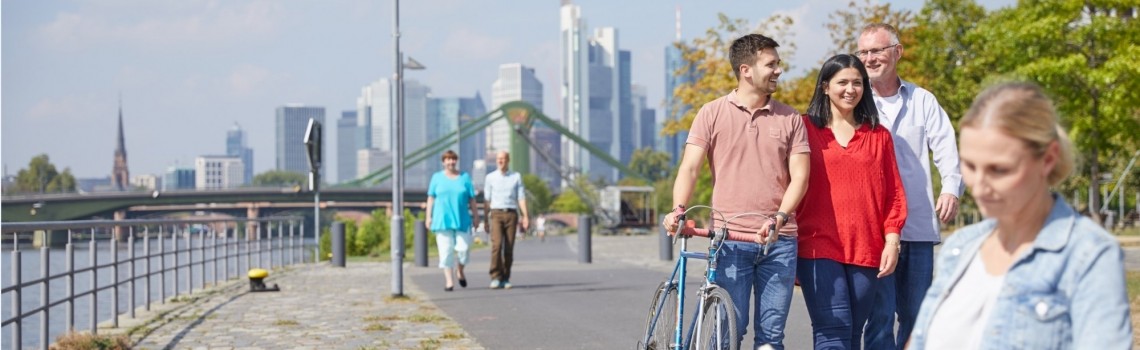Personen, die am Mainufer spazieren gehen