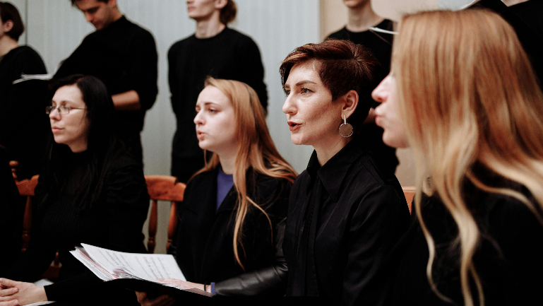 Eine Gruppe von Frauen sitzt zusammen und singt.