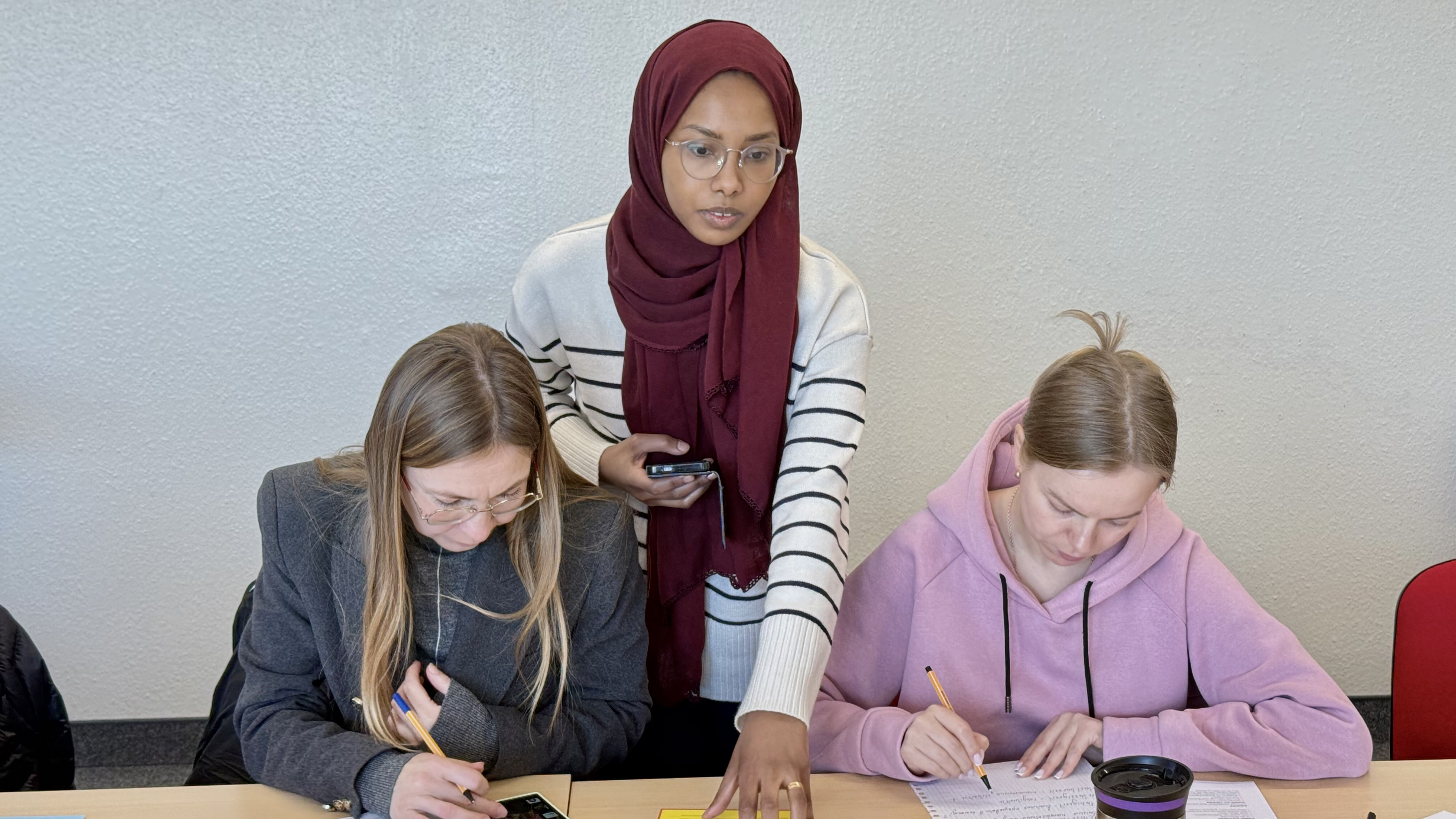 Personen stehend und sitzend in einer Lernsituation