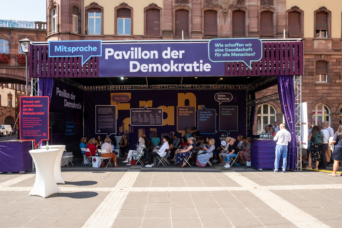 Der Pavillion der Demokratie mit Menschen darin und davor