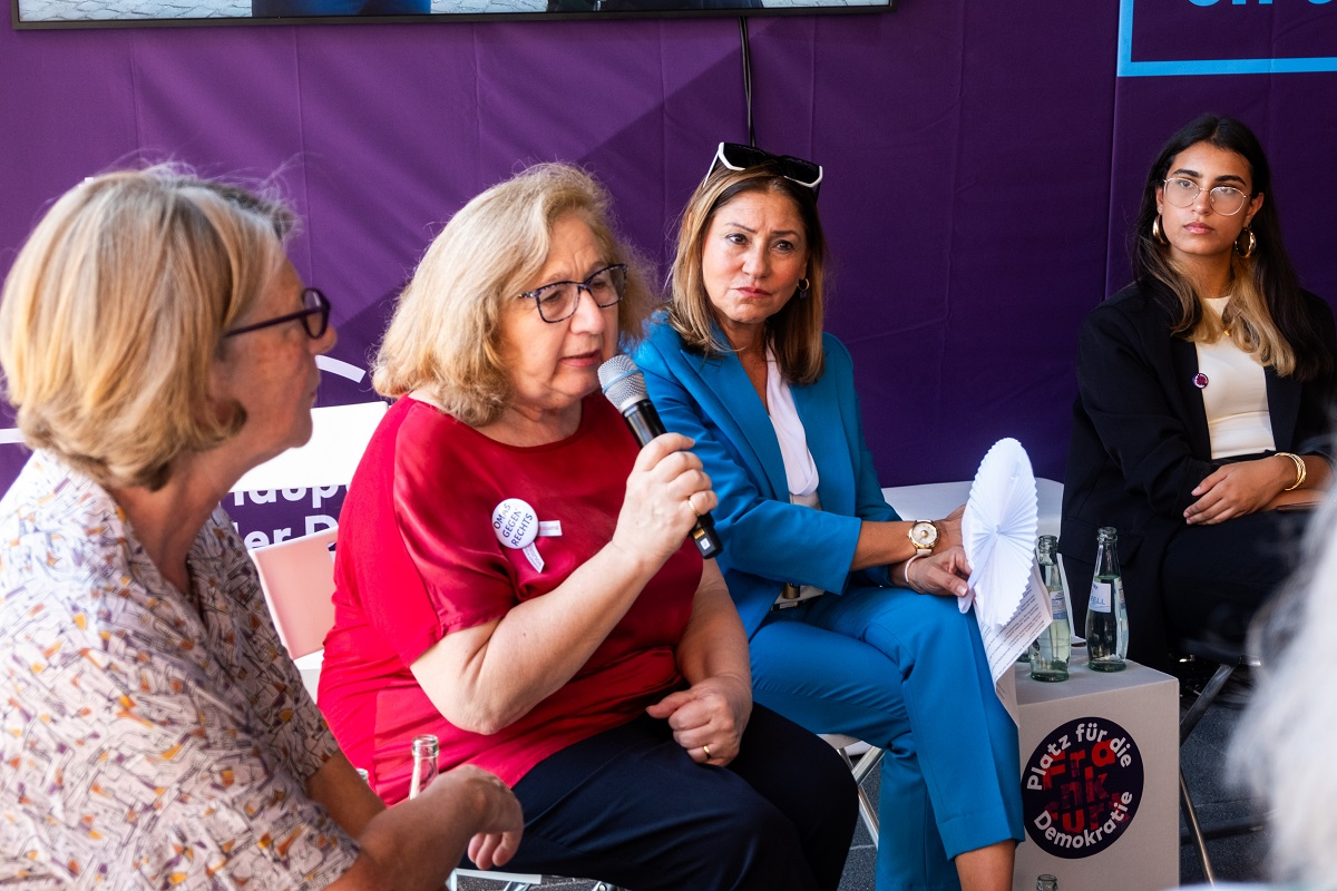 Die Omas gegen Rechts sprachen unter der Moderation von Sharzad Osterer mit Schüler:innen der Liebigschule. Omas gegen rechts diskutieren sitzend im Pavillon.