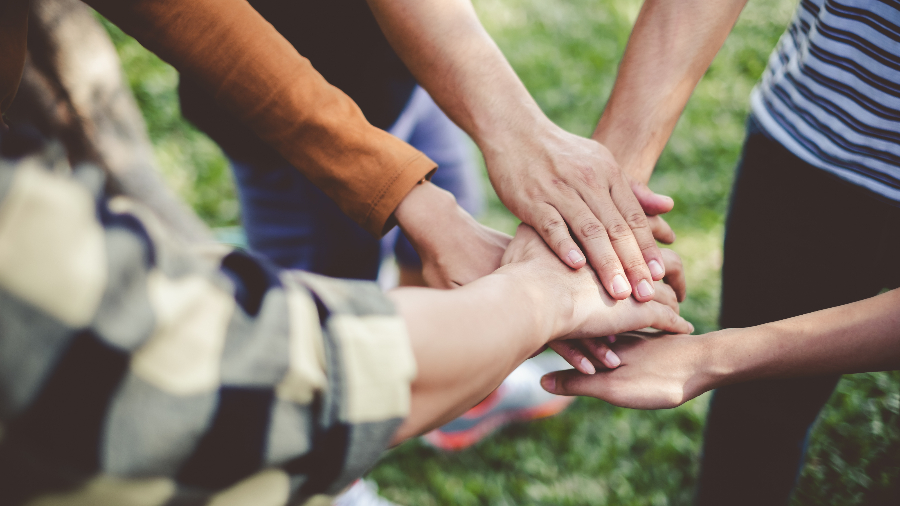Symbolfoto (©iStockphoto.com_Nattakorn Maneerat) Ausgestreckte Hände sind in einer Geste übereinandergelegt.