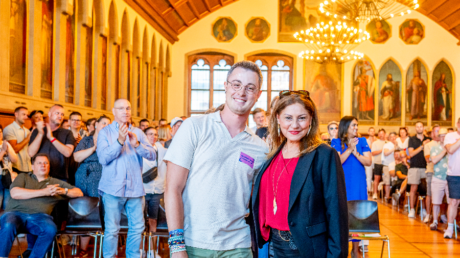 Bürgermeisterin Nargess Eskandari-Grünberg und Sebastian Reggentin, Pressesprecher des CSD, stehend Arm im Arm vor den Gästen im vollbesetzten Kaisersaal im Frankfurter Römer.