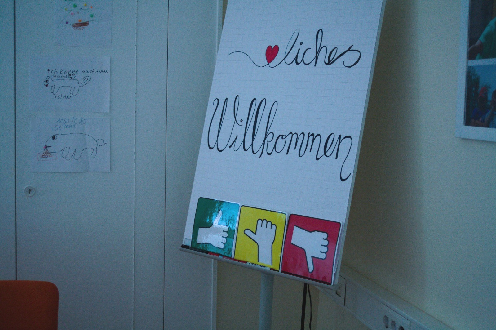 Flipchart mit Aufschrift "Herzlich Willkommen"