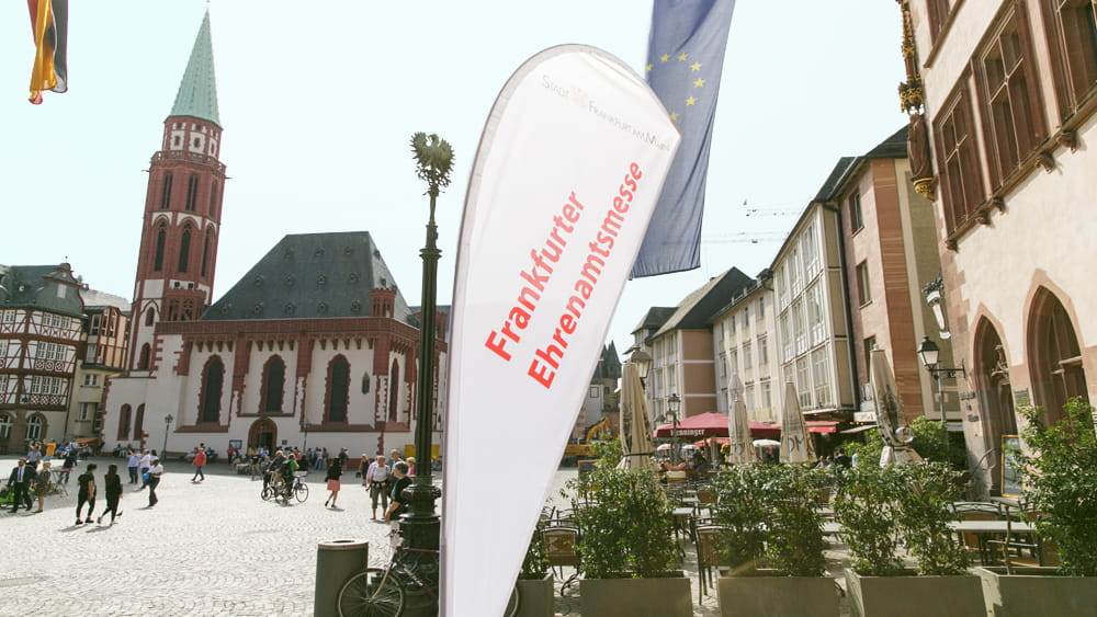 Blick auf den Platz vorm Rathaus Römer mit Beachflag mit Aufschrift "Ehrenamtsmesse"