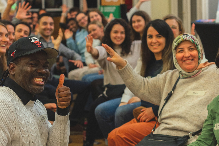 Personen des "Speak Buddy"-Programms mit aus Freude erhobenen Händenb
