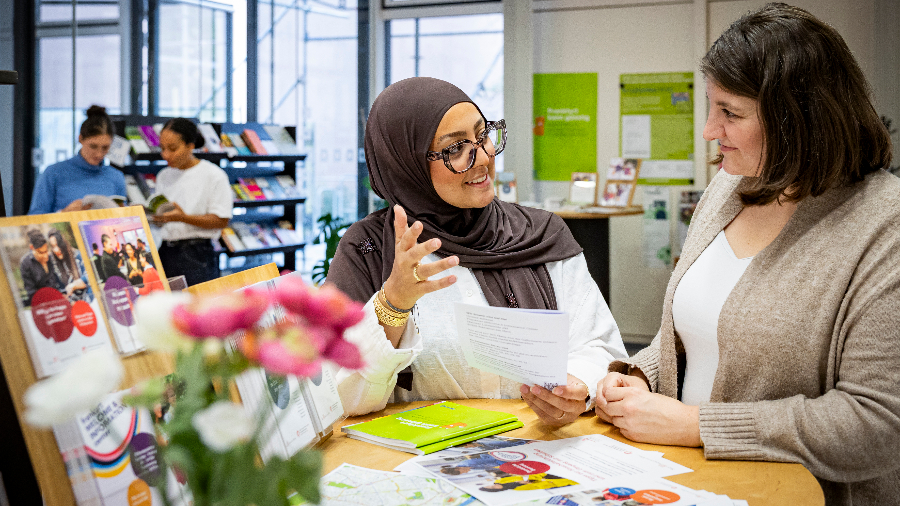 Zwei Personen stehend und gestikulierend in einem Beratungsgespräch