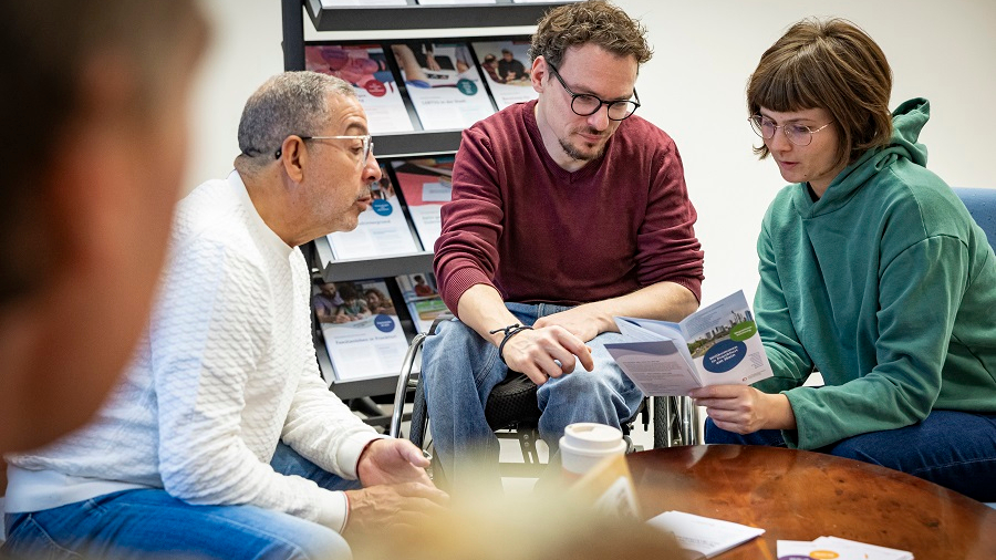 Drei Personen sitzend in einer Beratung