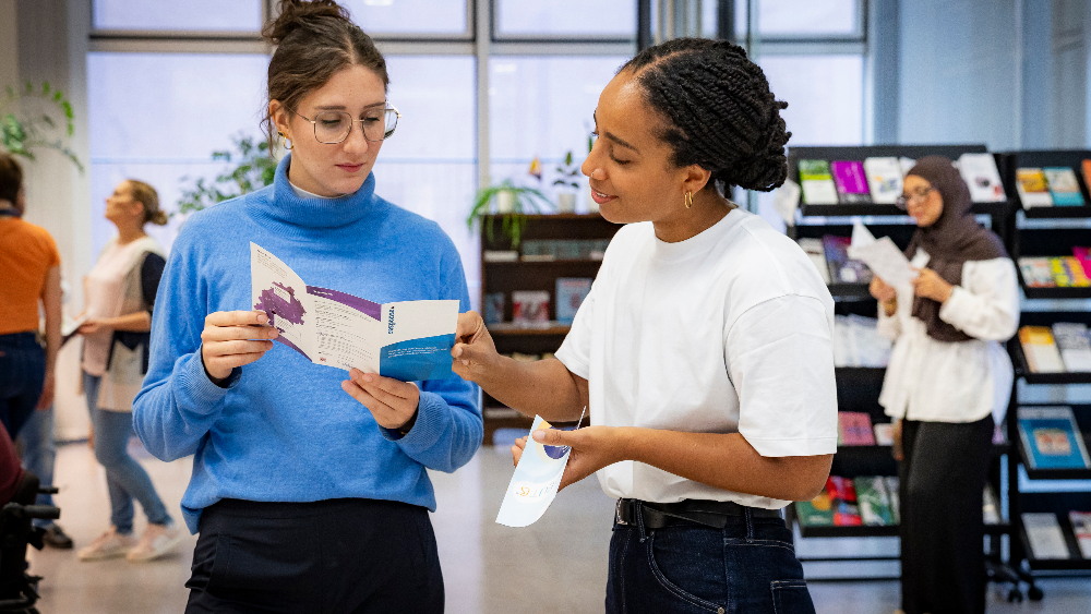 Zwei Personen stehend und gestikulierend in einer Beratung