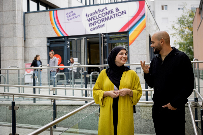 Zwei Personen unerhalten sich vor Gebäude