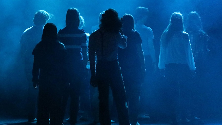 Jugendliche von hinten auf einer Theaterbühne