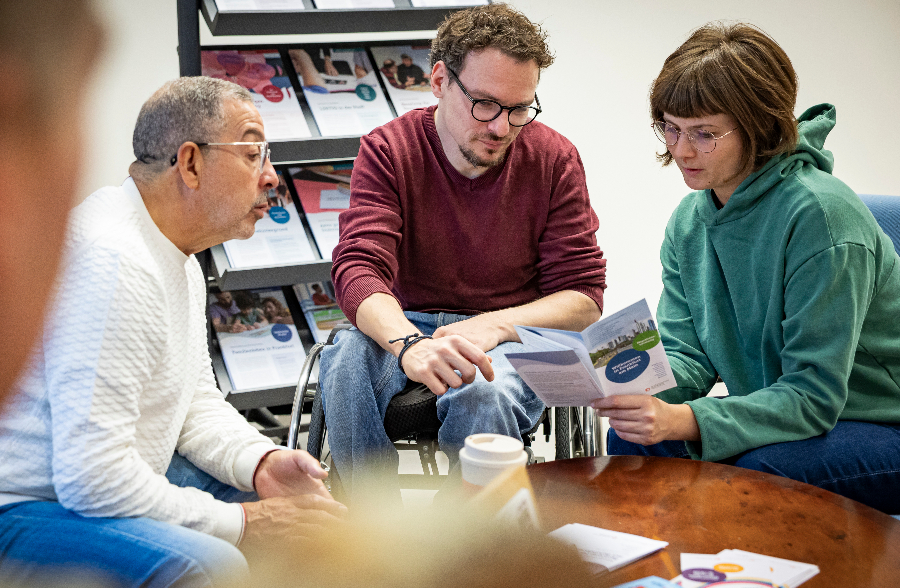 Drei Personen in einer Beratung sitzend