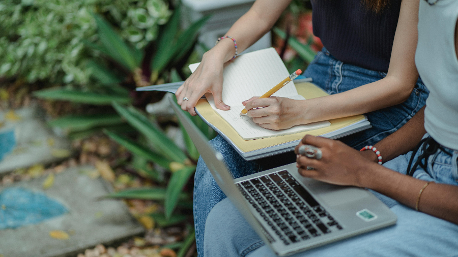 Zwei Personen mit Laptop und Notitzblock