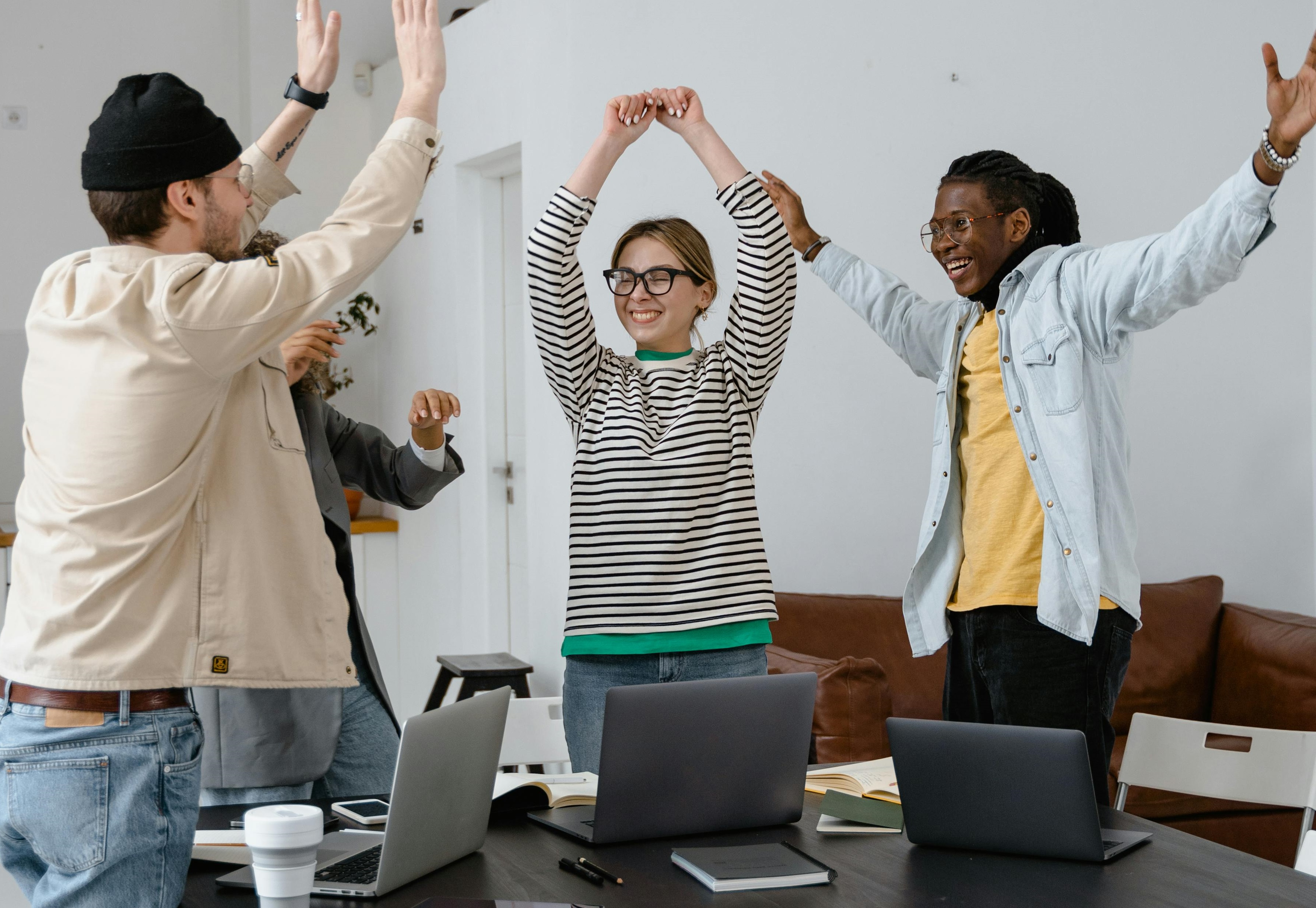 Mehrere Personen leicht jubelnd mit hochgestreckten Armen