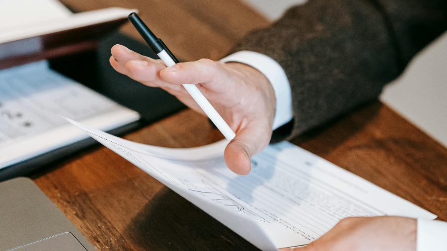 Hand einer Person mit Formular mit ablehnender Geste