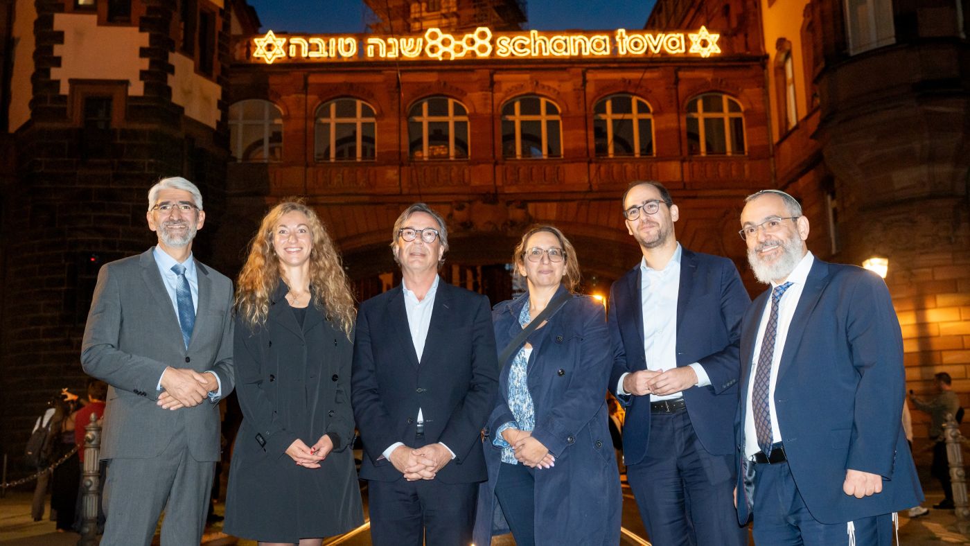 Die Seufzerbrücke des Römers mit erleuchtetem Gruß "Schana Tova". Davor stehend: Rabbiner Julian-Chaim Soussan, Stadträtin Tina Zapf-Rodríguez, Marc Grünbaum, Vorstandsvorsitzender der Jüdischen Gemeinde Frankfurt, Jennifer Marställer, Direktorin der Jüdischen Gemeinde Frankfurt, Benjamin Graumann, Vorstandsvorsitzender der Jüdischen Gemeinde Frankfurt, und Rabbiner Avichai Apel