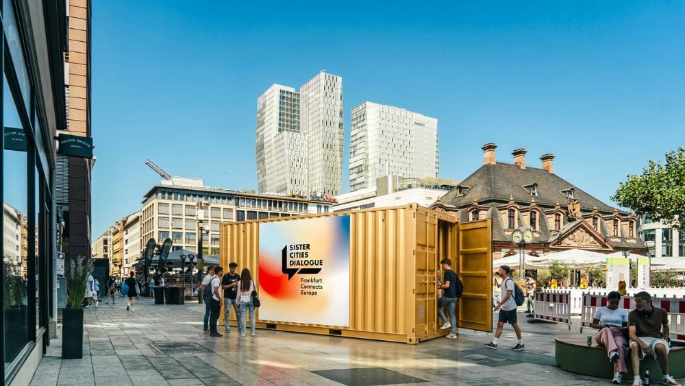 Zum Teil KI-generierte Ansicht des "Sister Cities Dialogue"-Portals an der Hauptwache in Form eines Wohncontainers