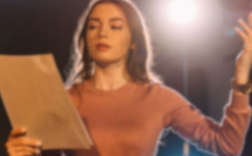 Eine Frau auf einer Bühne mit Textnotizen in der Hand