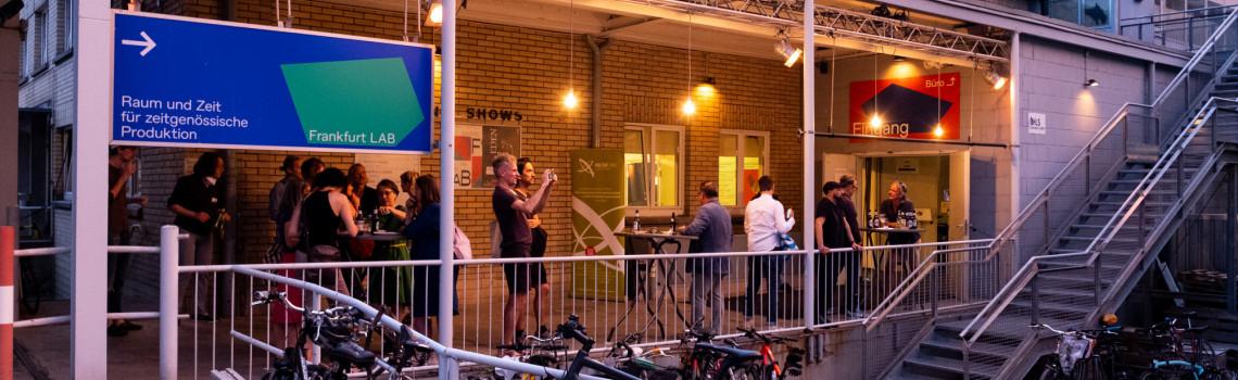 Blick auf die Terasse von Frankfurt LAB e. V. mit Personen darauf